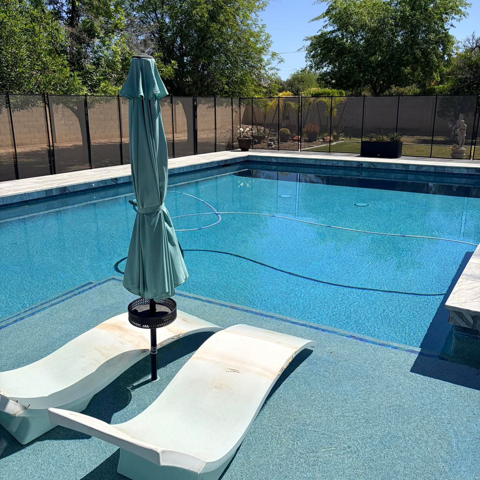 Pool with tanning ledge and loungers, clear water